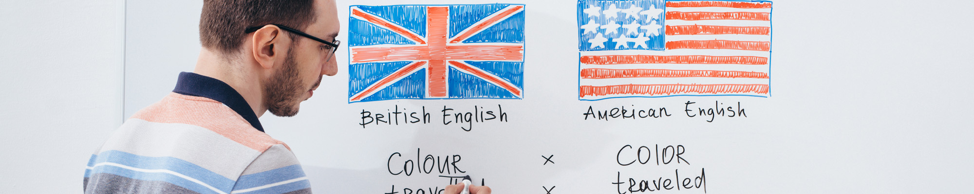 man writing on white board, words in American English and British English